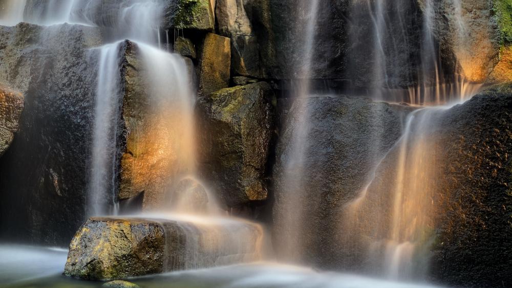 Golden Mist Waterfall Over Ancient Granite Boulders in Crisp 4K wallpaper
