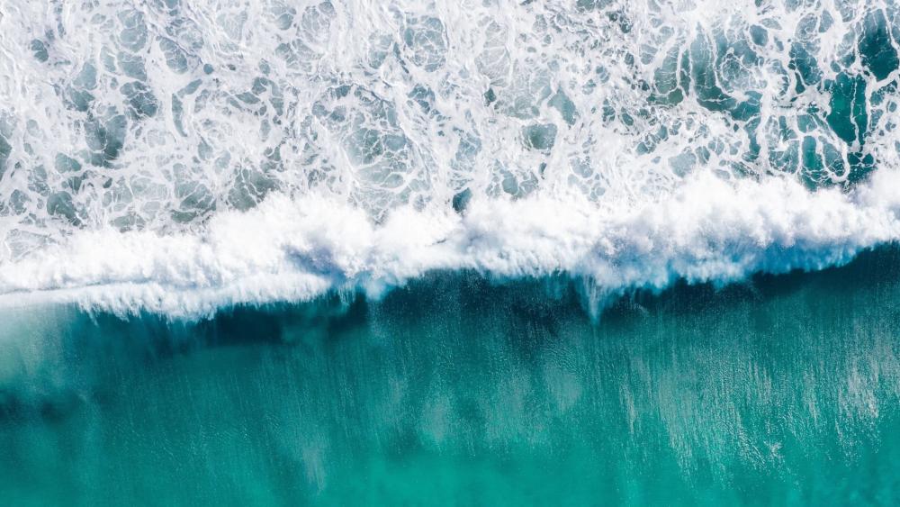 Aerial Tide Line Where Sea Waves Fold Into Turquoise Calm wallpaper