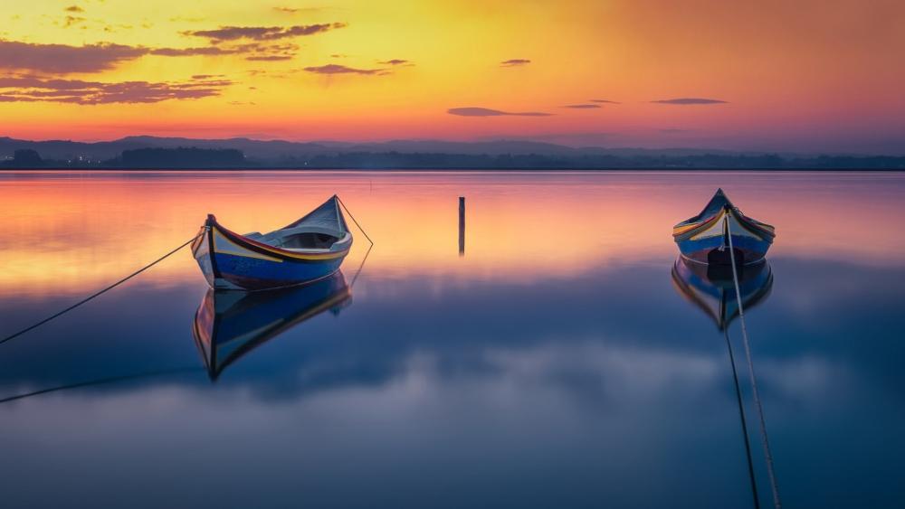 Moored Boats on a Tranquil Lake at Golden Sunset Horizon wallpaper