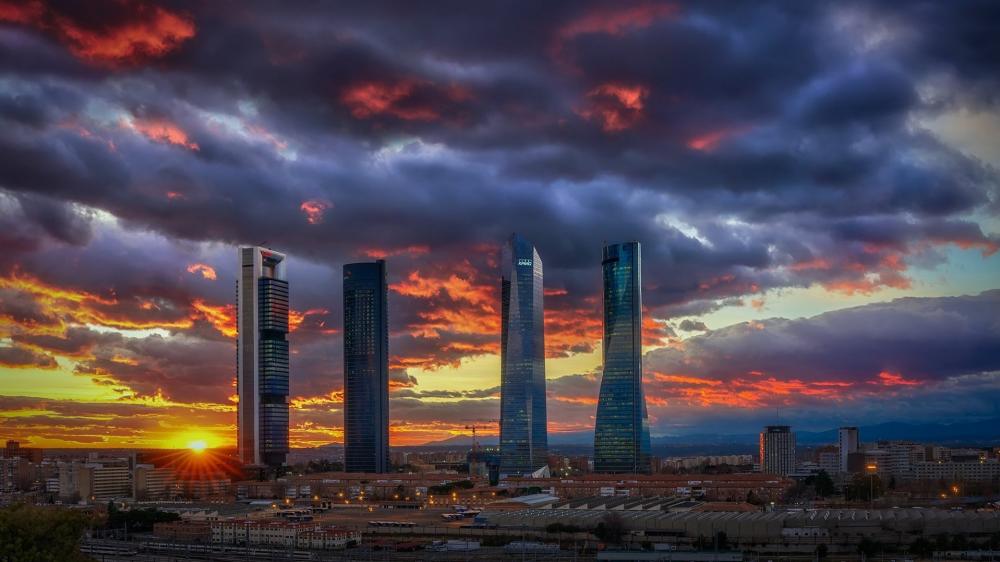Sunset Over Madrid Cuatro Torres Skyline in Dramatic Cloudscape wallpaper