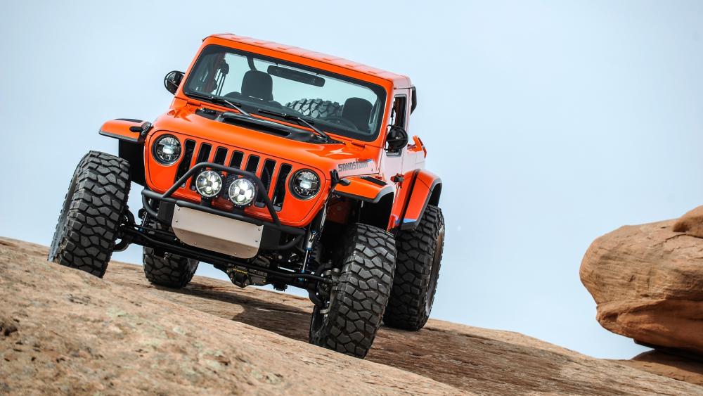 Jeep Sandstorm Conquering Rugged Rock Trails in Vibrant Orange wallpaper