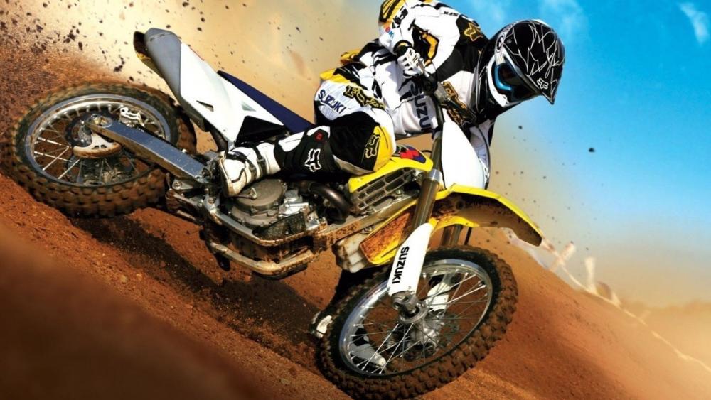 Suzuki Motocross Rider Carving a Dirt Berm in Full Speed wallpaper