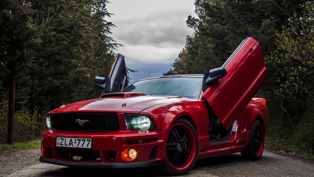 Red Ford Mustang Muscle Car with Vertical Doors in Forest Road wallpaper