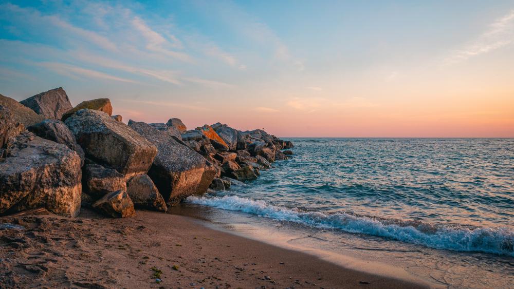 Sunset Serenity Along the Rocky Breakwater Shore wallpaper
