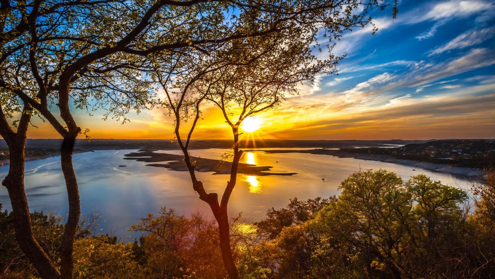 Golden Sunset Over Lake Travis Through Hill Country Trees wallpaper