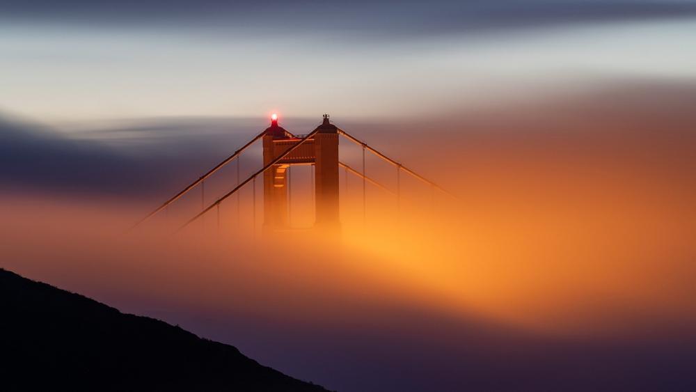 Golden Gate Bridge Emerging Through Fog at Dusk in San Francisco wallpaper