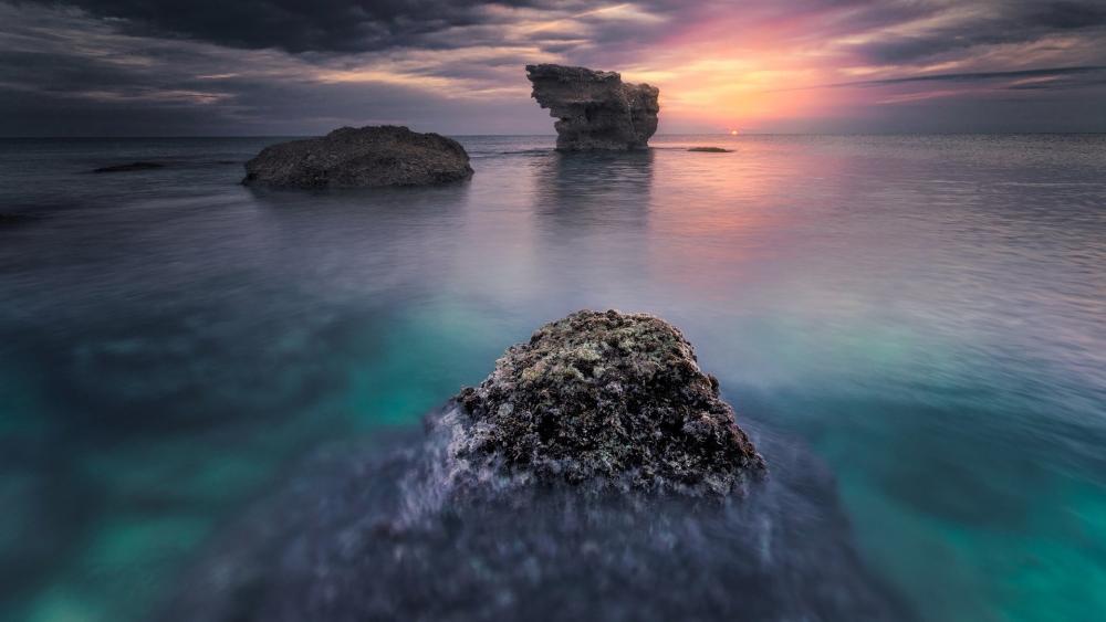 Serene Ocean Dusk Over Tranquil Rocks wallpaper