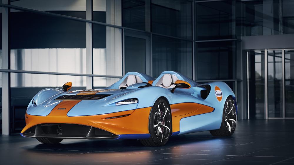 McLaren Elva Gulf Livery Supercar in Sleek Modern Showroom wallpaper