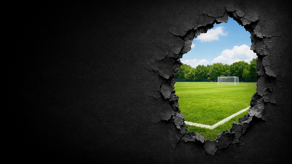 Breakthrough View to the Soccer Pitch Beyond the Wall wallpaper