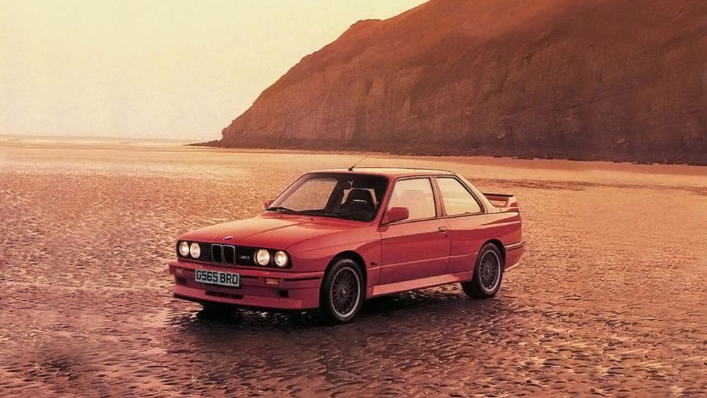 Classic BMW Coupe on Golden Beach at Sunset Serenity wallpaper