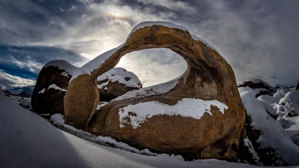 Snow Dusted Mobius Arch Under Dramatic California Winter Sky wallpaper