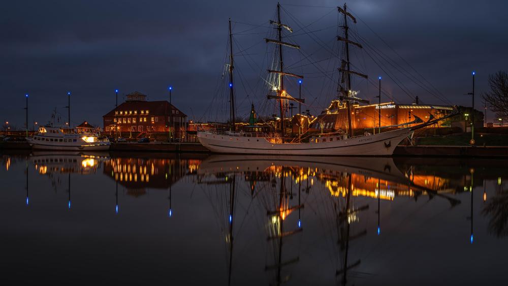 Meridianas Tall Ship Glowing Over the Danė River Reflection at Night wallpaper
