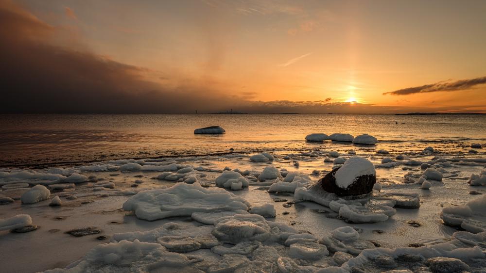 Golden Dusk Over Frozen Shoreline and Quiet Sea Horizon wallpaper