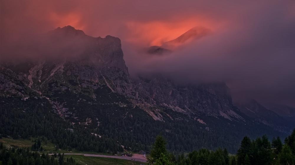 Crimson Dawn Over the Foggy Dolomites Mountain Peaks in Italy wallpaper