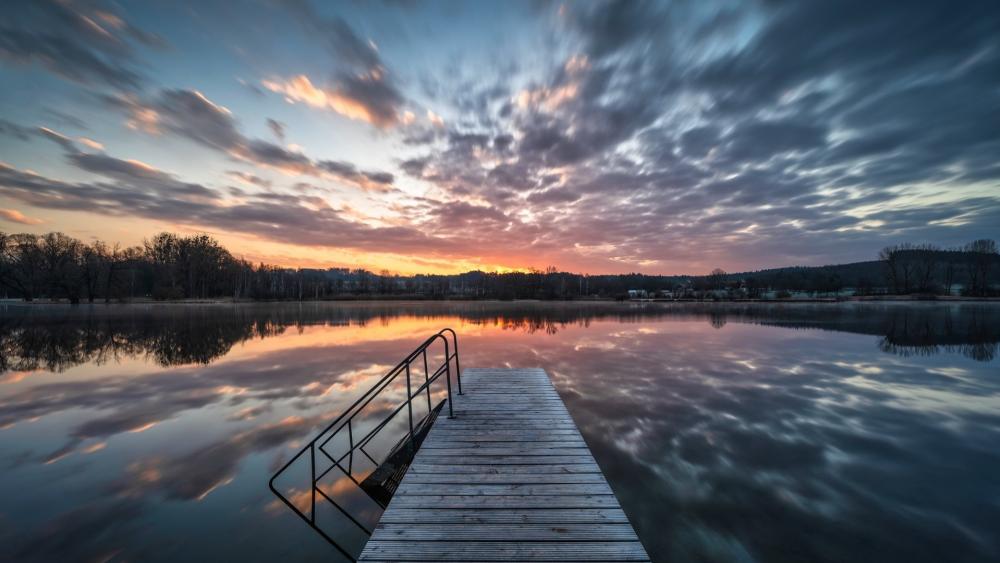 Sunrise Reflections Along a Quiet Lakeside Pier wallpaper