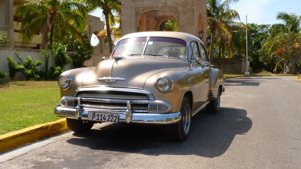 Sunlit 1951 Chevrolet Bel Air Classic on a Palm Lined Road wallpaper