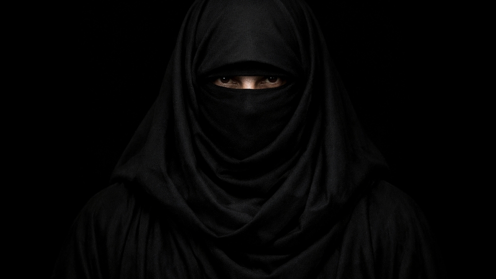 Silent Gaze in Shadowed Niqab Minimal Portrait on Black Background wallpaper