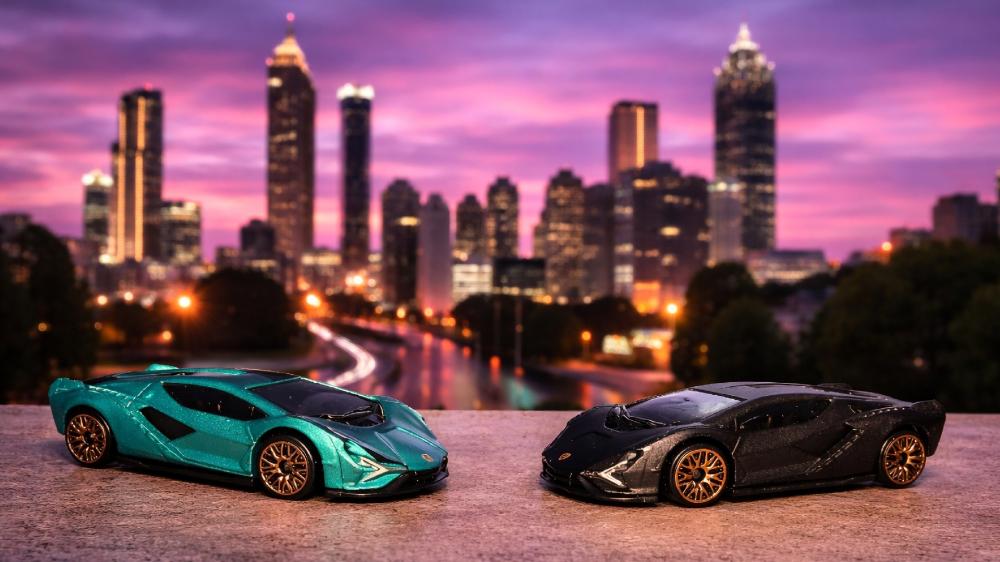 Twin Lamborghini Sián Model Cars Against a Neon City Skyline wallpaper