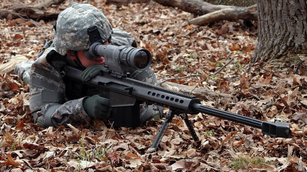 Camouflaged Marksman Taking Aim in Autumn Woodland wallpaper