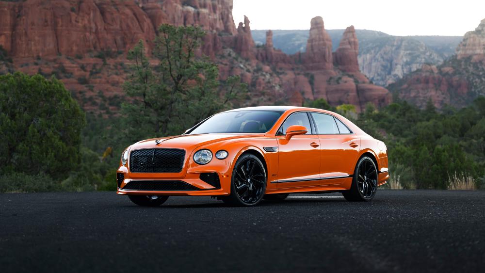 Orange Bentley Luxury Against Desert Cliffs wallpaper