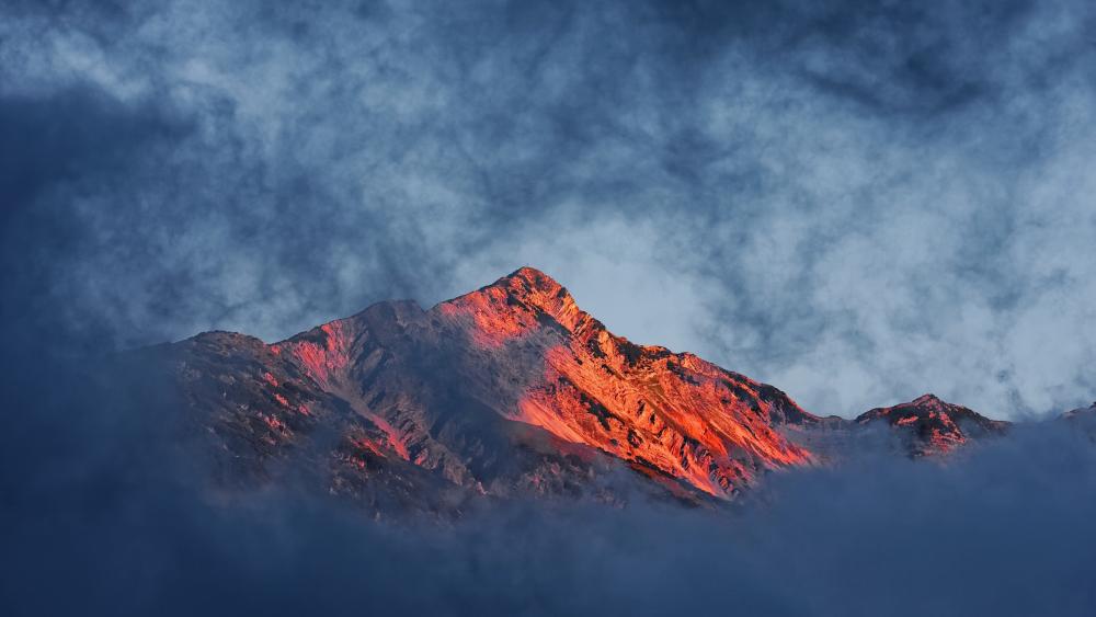 Sunlit Peak Above the Clouds wallpaper
