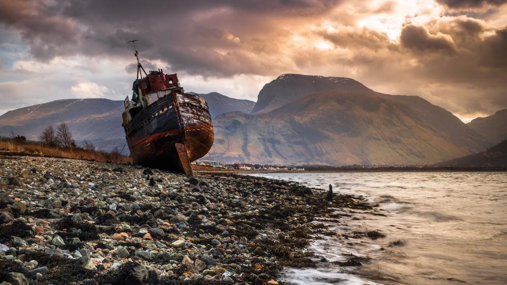Rusty Shipwreck on a Rocky Coast wallpaper