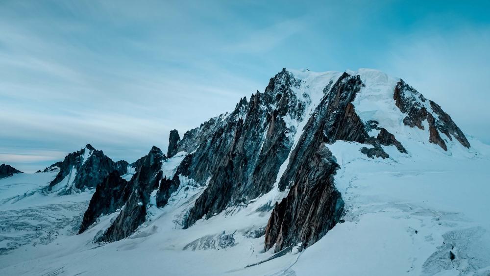 Snowcapped Peaks Under Winter Sky wallpaper