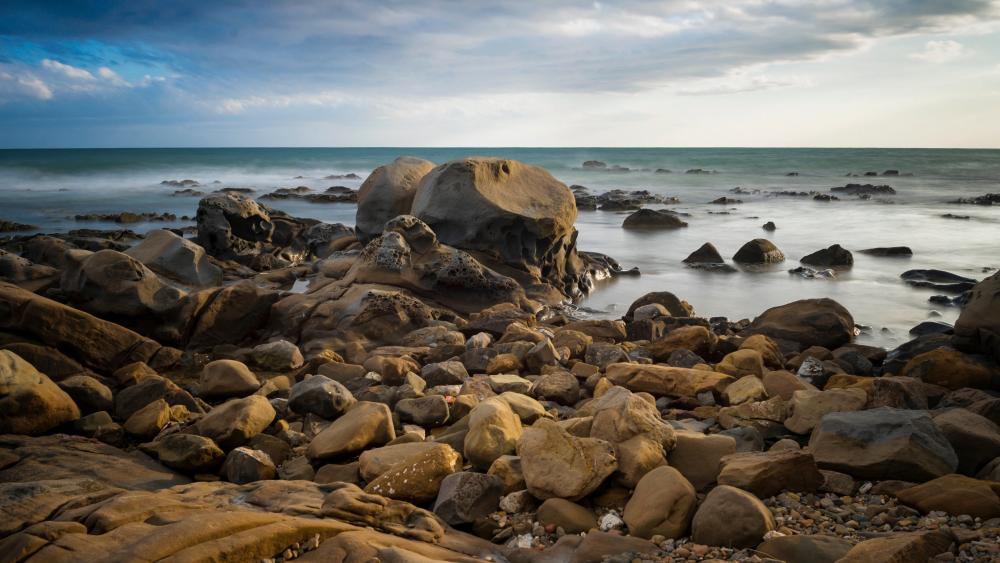 Rocky Coastline Beneath a Calm Horizon wallpaper