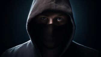 Hooded Enigma Revealed in Shadows wallpaper