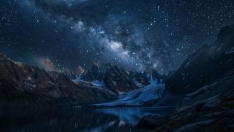 Starry Night Over Mountain Peaks and Glacial Lake in 4K wallpaper