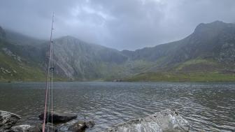 Serene Fishing Lake in Misty Mountains wallpaper