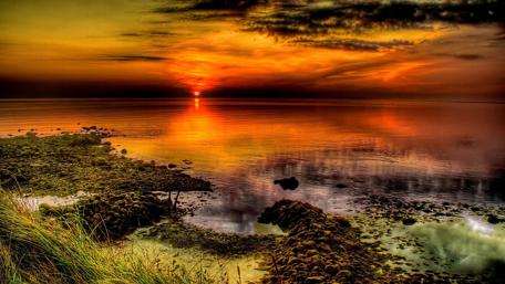 Fiery Sunset Over Tranquil Waters wallpaper