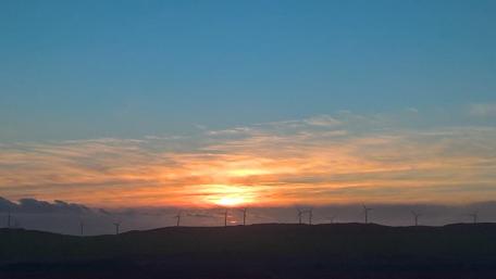 Breathtaking Sunset Over Wind Turbines wallpaper