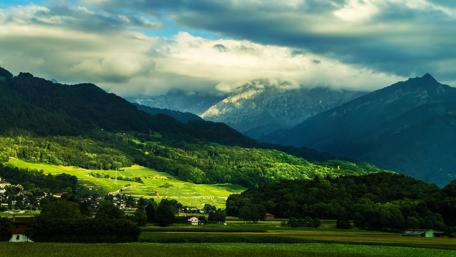 Serene Mountain Landscape Under Cloudy Skies wallpaper