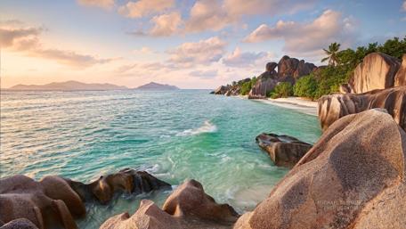 Serene Beach at Sunset with Rocky Shore wallpaper