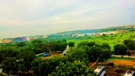 Lush Green Landscape Under Cloudy Skies wallpaper