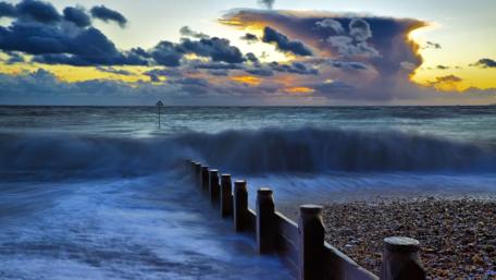 Stormy Sunset Over Turbulent Waves wallpaper