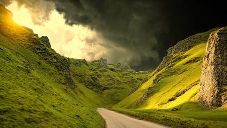 Mountain Road Through Lush Green Hills wallpaper