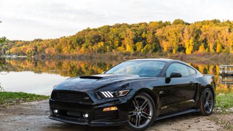 Sleek Black Car by the Lake wallpaper