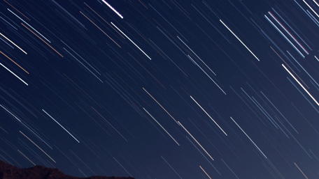 Star Trails in the Night Sky Over Mountains wallpaper