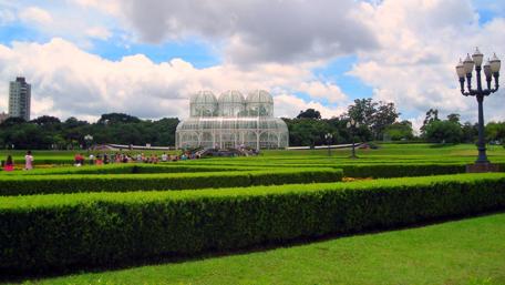 Serene City Park with Lush Greenery and Glass Structure wallpaper