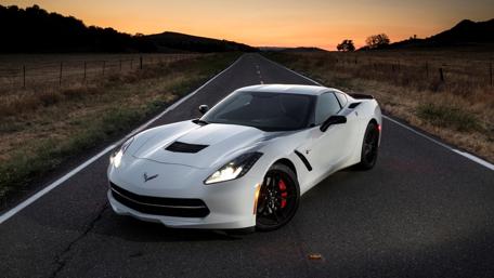 Sleek White Sports Car Against Sunset Roadway wallpaper