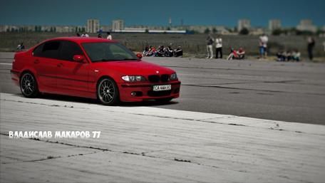 Dynamic Red BMW on the Track Amidst Spectators wallpaper