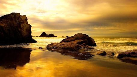 Golden Sunset Over Rocky Shoreline wallpaper