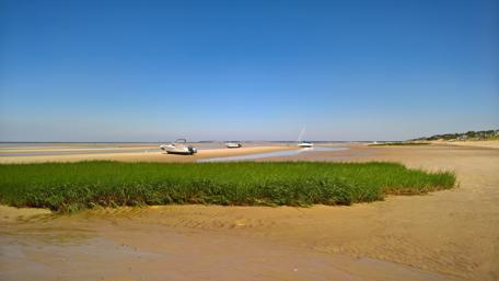 Serene Beach with Boats Under Clear Blue Sky wallpaper