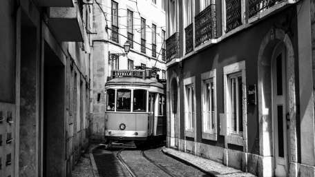Historic Lisbon Tram Navigates Narrow Streets wallpaper