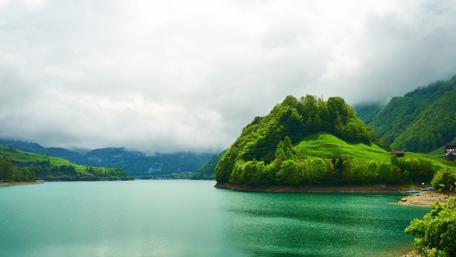 Serene Lake Amidst Lush Green Mountains wallpaper