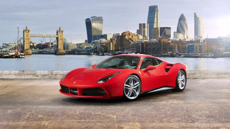 Sleek Red Dream Car by the River wallpaper