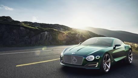 Sleek Green Car on Scenic Roadway wallpaper