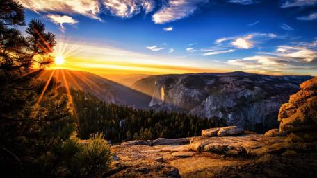 Breathtaking View of Sunset Over Mountains and Forests wallpaper